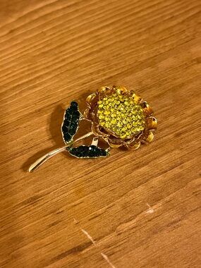 Golden sunflower brooch on gold tone back with fold under clasp 1 3/4 “
